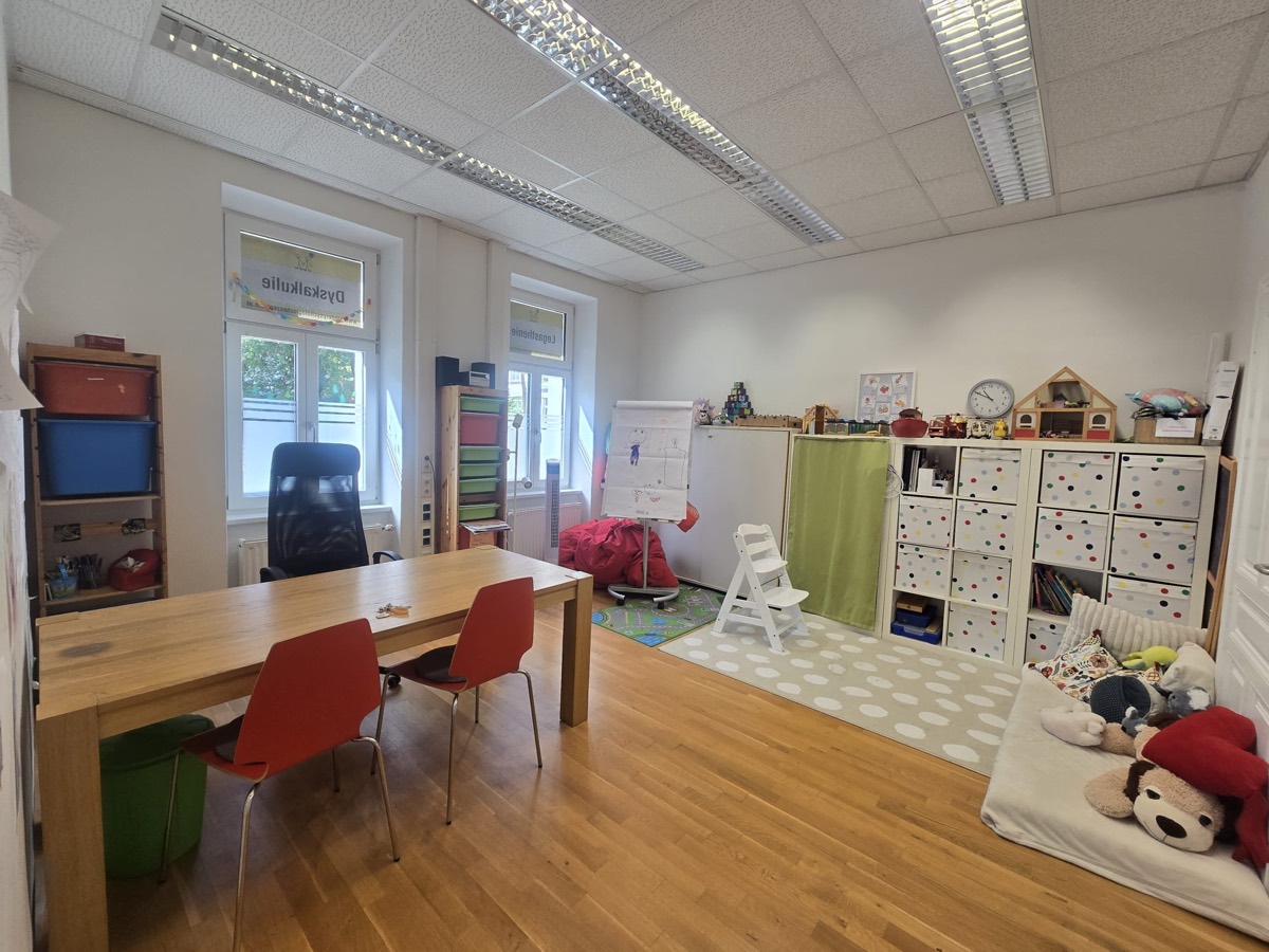 Trainingsraum im Kinderpsychologischen Zentrum Mödling mit Arbeitstisch, Spielbereich und Materialregalen